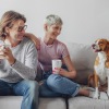 A couple on a couch with their dog